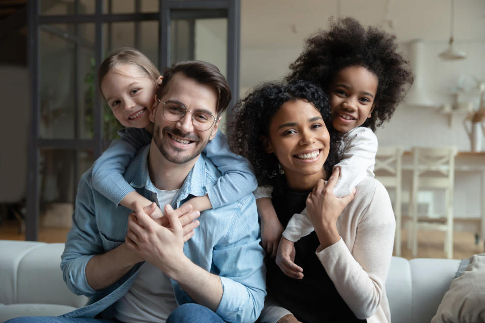 A couple smiles with their two daughters