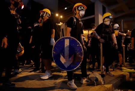 An anti-extradition demonstrator holds a makeshift shield made out of a road sign, after a march to call for democratic reforms in Hong Kong