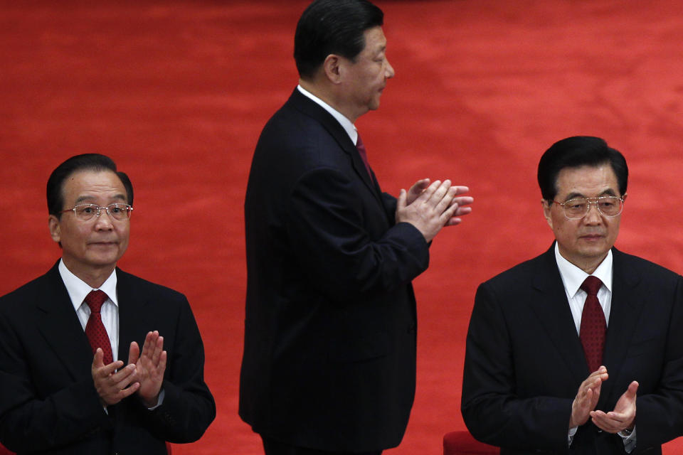 FILE - In this May 4, 2012 file photo, Chinese President Hu Jintao, right, Premier Wen Jiabao, left, and Vice President Xi Jinping, center, clap as they arrive for a conference to celebrate the 90th anniversary of the founding of the Chinese Communist Youth League at the Great Hall of the People in Beijing. The world's two biggest economies are entering the final stages of political campaigns to pick their national leaders. While American candidates wage loud, rah-rah campaigns with a clear timetable as they head toward the Nov. 6 presidential election, China hasn’t even announced the date for this fall’s Communist Party congress that will appoint the next top leader to replace outgoing Hu Jintao - a post widely expected to go to Vice President Xi Jinping. (AP Photo/Alexander F. Yuan, File)
