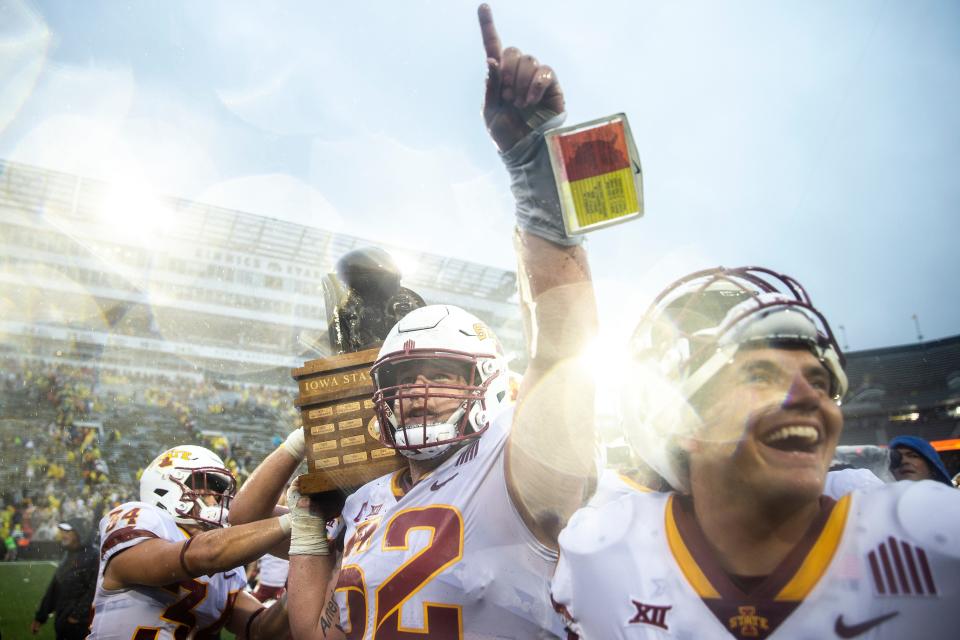 Iowa State offensive lineman Trevor Downing celebrates with the Cy-Hawk trophy.