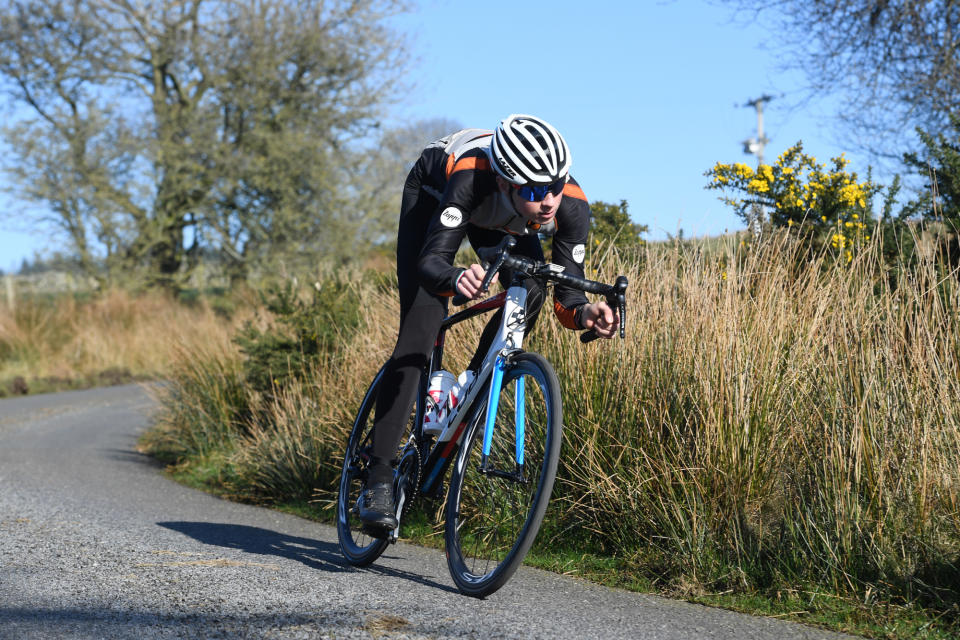 Male cyclist riding in a tucked position