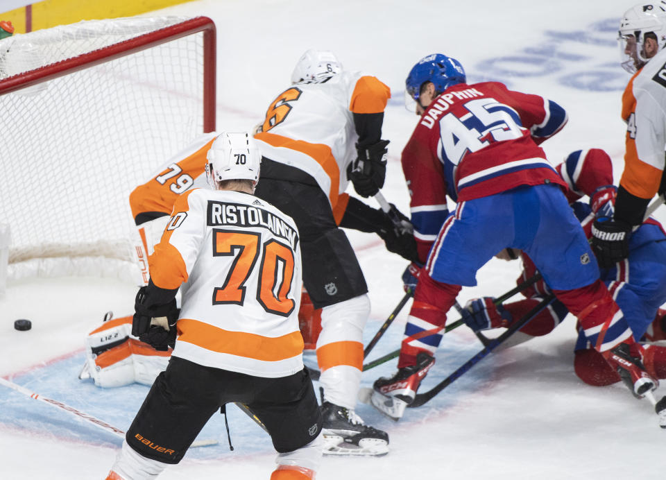 Montreal Canadiens' Laurent Dauphin (45) scores against Philadelphia Flyers goaltender Carter Hart (79) as Flyers' Travis Sanheim (6) defends during third-period NHL hockey game action in Montreal, Thursday, Dec. 16, 2021. (Graham Hughes/The Canadian Press via AP)