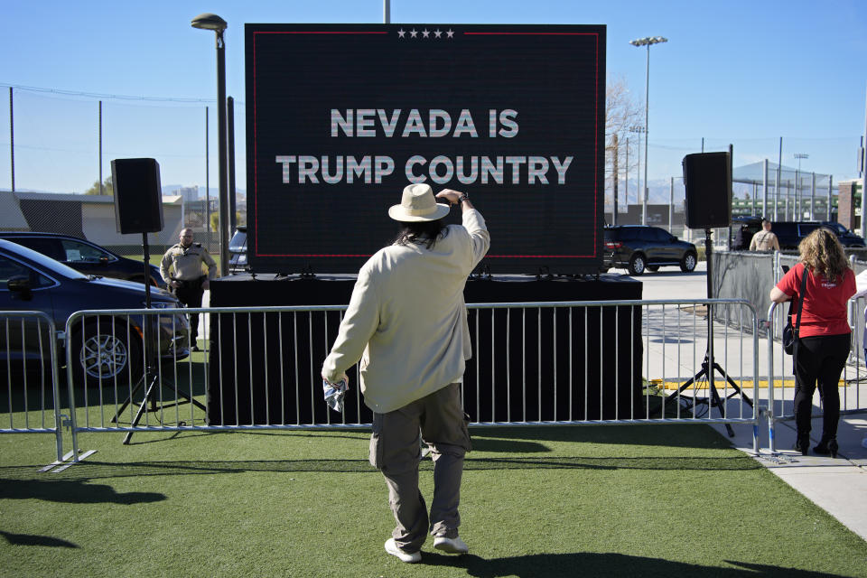 FILE - A person takes a picture of a screen before Republican presidential candidate former President Donald Trump speaks at a campaign event Jan. 27, 2024, in Las Vegas. (AP Photo/John Locher, File)