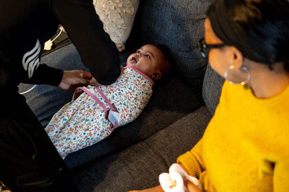 DeJuan Bland swaddles his daughter Wynter Bland, 4 months, as his wife Jenise Bland looks on during a post-natal visit by Doula Erika Millender at their home in Dearborn on January 12, 2023.
Doulas serve birthing people prenatally, during labor and delivery and after a baby is born. Clients typically pay out of pocket for doula services, which have been proven to improve maternal and infant health outcomes.
Effective Jan. 1, Michigan Medicaid will reimburse doulas for their services. The state says it's in part an effort to increase equity and address racial disparities. Doulas see the policy as a positive validation of their work but are disappointed by the relatively low rate at which Medicaid will reimburse.