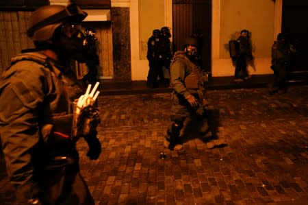 Police clash with demonstrators during a protest calling for the resignation of Governor Ricardo Rossello in San Juan