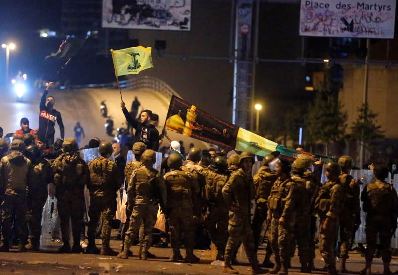 Supporters of the Lebanese Shi'ite groups Hezbollah and Amal carry flags as Lebanese army soldiers are deployed in Beirut