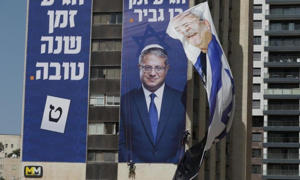 Workers hang an election banner for Itamar Ben-Gvir in Jerusalem