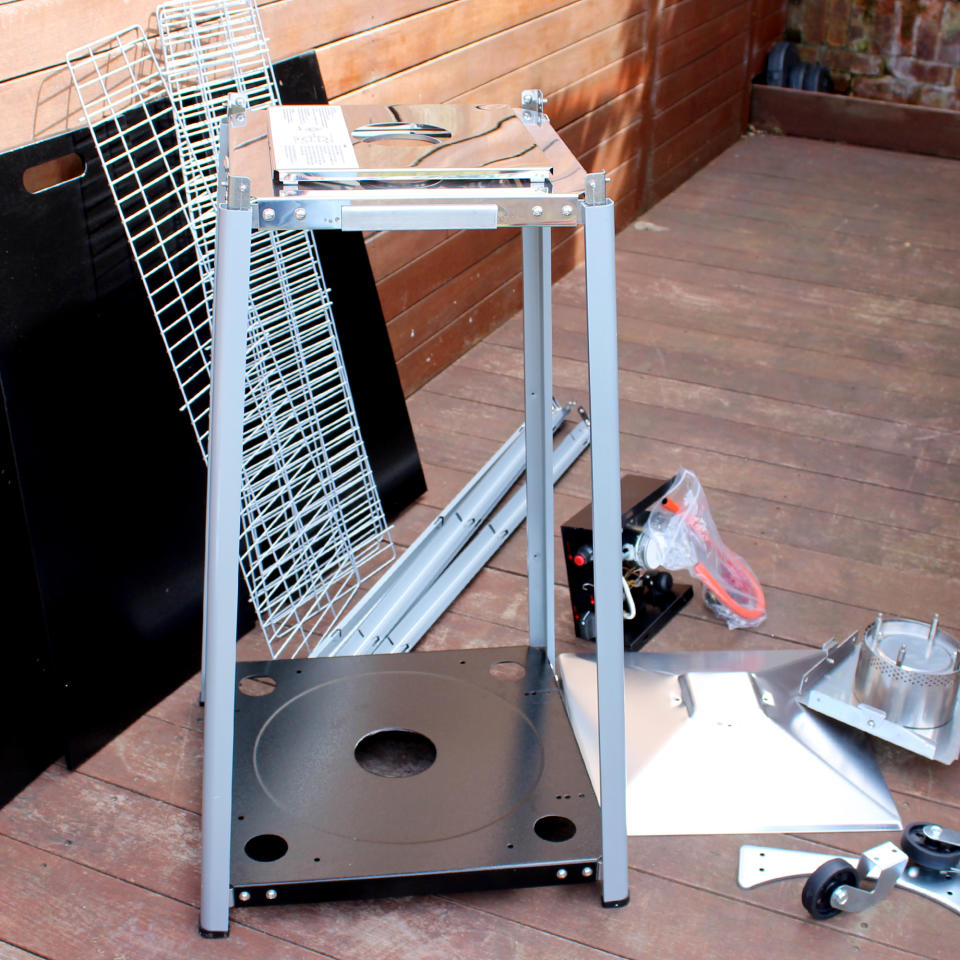 The Outsunny 11.2kw Pyramid Gas Patio Heater being assembled on wooden decking