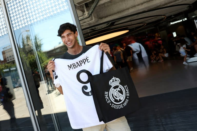 Un hombre sonríe tras comprar la camiseta de Kylian Mbappé, nuevo jugador del Real Madrid, en el Santiago Bernabéu el 11 de julio (Pierre-Philippe MARCOU)