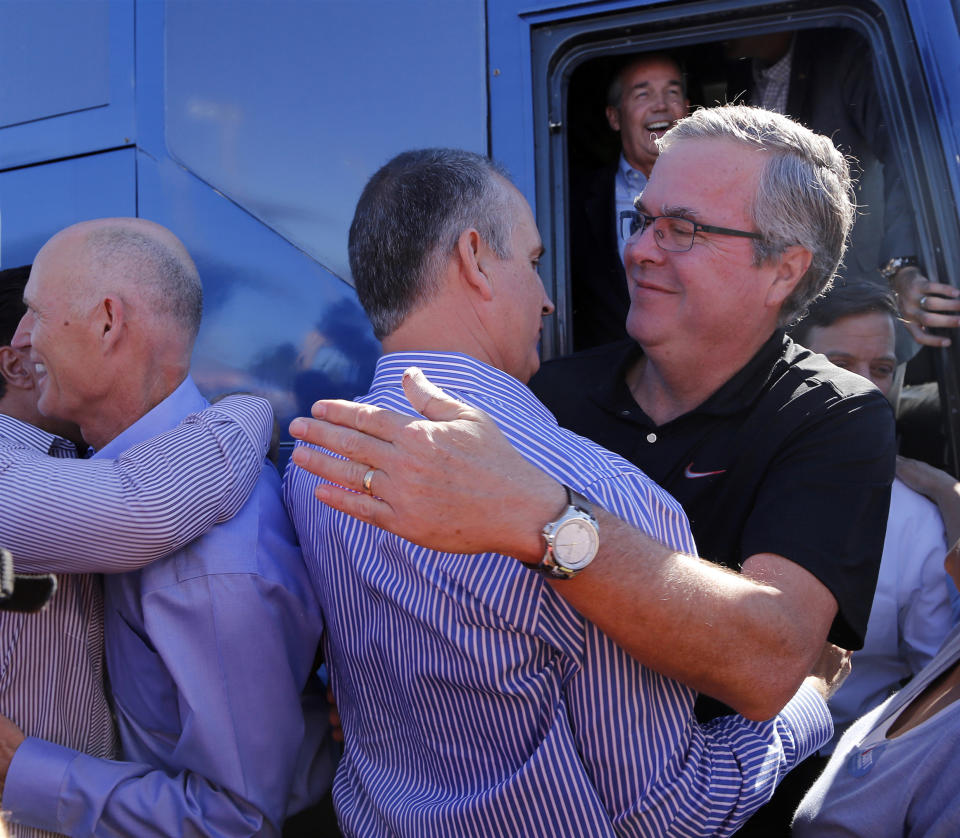 Governor Rick Scott (left) greets supporters as Jeb Bush embraces Rep. Mario Diaz-Balart (R-Fla.). (Carl Juste/Miami Herald/TNS via Getty Images)