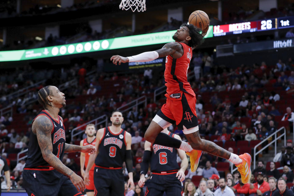 Houston Rockets guard Jalen Green, top, dunks over Chicago Bulls forward DeMar DeRozan (11), center Nikola Vucevic (9), and guard Alex Caruso, back right, during the first half of an NBA basketball game Thursday, March 21, 2024, in Houston. (AP Photo/Michael Wyke)