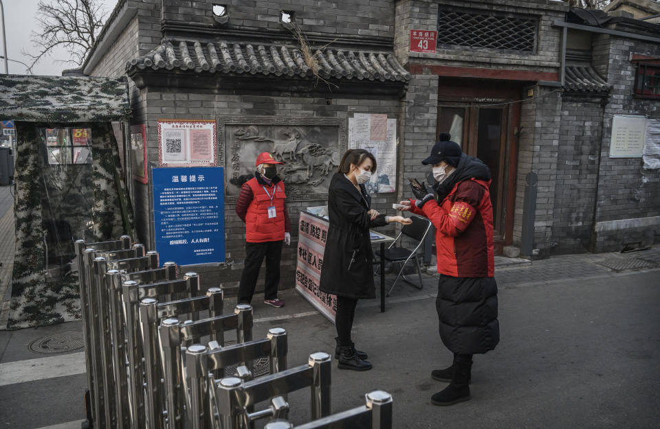 BEIJING, CHINA - FEBRUARY 19: Members of a local neighbourhood committee wear protective masks as they check the temperature of a resident entering at a barricade placed to control people entering and exiting a local hutong as part of government efforts to control the spread of the coronavirus on February 19, 2020 in Beijing, China. The number of cases of the deadly new coronavirus COVID-19 rose to more than 58000  in mainland China Wednesday, in what the World Health Organization (WHO) has declared a global public health emergency. China continued to lock down the city of Wuhan in an effort to contain the spread of the pneumonia-like disease which medicals experts have confirmed can be passed from human to human. In an unprecedented move, Chinese authorities have maintained and in some cases tightened the travel restrictions on the city which is the epicentre of the virus and also in municipalities in other parts of the country affecting tens of millions of people. The number of those who have died from the virus in China climbed to over 2000 on Wednesday mostly in Hubei province, and cases have been reported in other countries including the United States, Canada, Australia, Japan, South Korea, India, the United Kingdom, Germany, France and several others. The World Health Organization has warned all governments to be on alert and screening has been stepped up at airports around the world. Some countries, including the United States, have put restrictions on Chinese travellers entering and advised their citizens against travel to China. (Photo by Kevin Frayer/Getty Images)