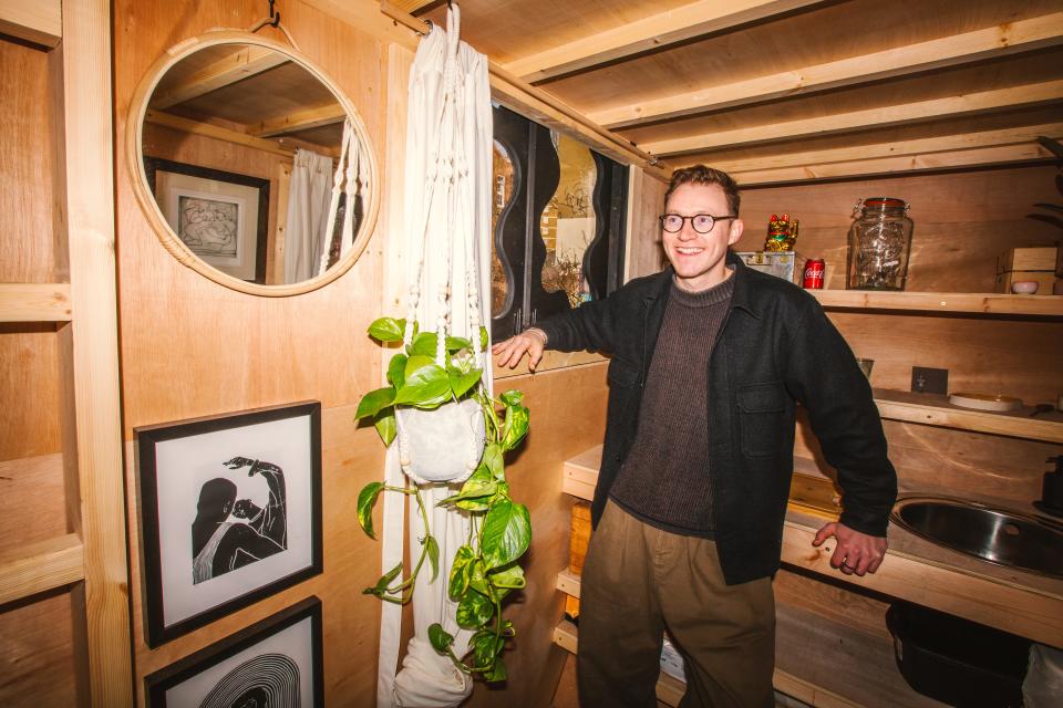 Harrison Marshall smiling inside of his tiny home