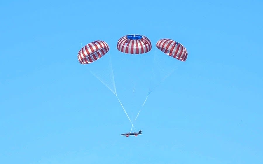 An XQ-58A descending under its parachutes after a mission. <em>Kratos</em>