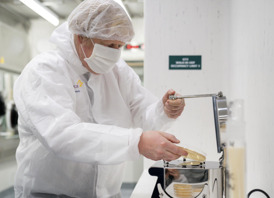 Britain's Prime Minister Boris Johnson, dressed in protective gear as he tries equipment during a visit to the AstraZeneca facility in Macclesfield, England, on Tuesday April 6, 2021, to learn more about their dollars 500 million investment into the site. Johnson said Monday that Britain’s vaccination program is going well and infections are falling, confirming that many shops and businesses will be allowed to reopen next week. (Dave Thompson/Pool via AP)