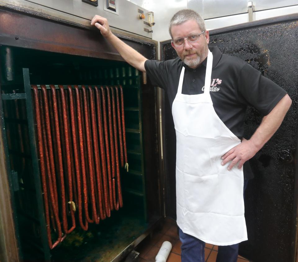 Al's Quality Market owner Dennis Gray stands by his smoker on Wednesday, August 16, 2023 in Barberton, Ohio. The Market has been a fixture in Barberton for 75 years.