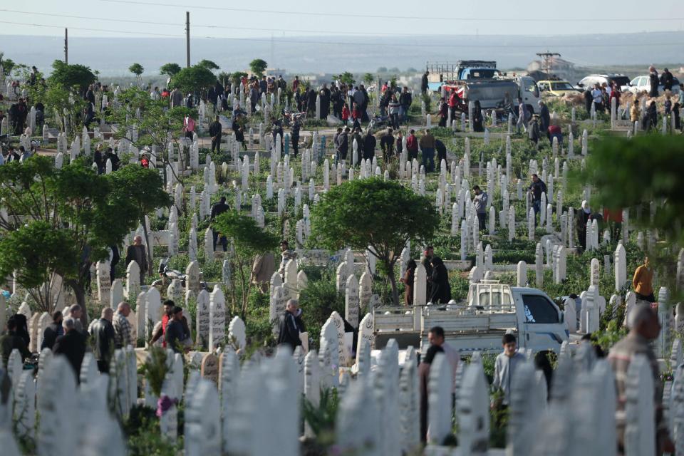 Muslims gather to pray at the graves of loved ones after the morning prayer at a cemetery in Syria's rebel-held northwestern city of Idlib (OMAR HAJ KADOUR/AFP via Getty Images)