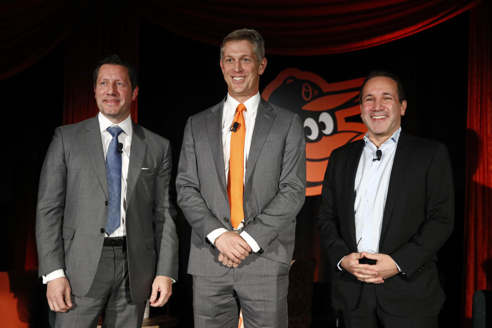 FILE - Mike Elias, center, the Baltimore Orioles' new executive vice president and general manager, poses for a photo with Orioles ownership representative Louis Angelos, left, and executive vice president John Angelos, right, after a baseball news conference Nov. 19, 2018, in Baltimore. Orioles CEO John Angelos was accused in a lawsuit this week of seizing control of the team at the expense of his brother Lou — and in defiance of their father Peter's wishes. (AP Photo/Patrick Semansky, File)