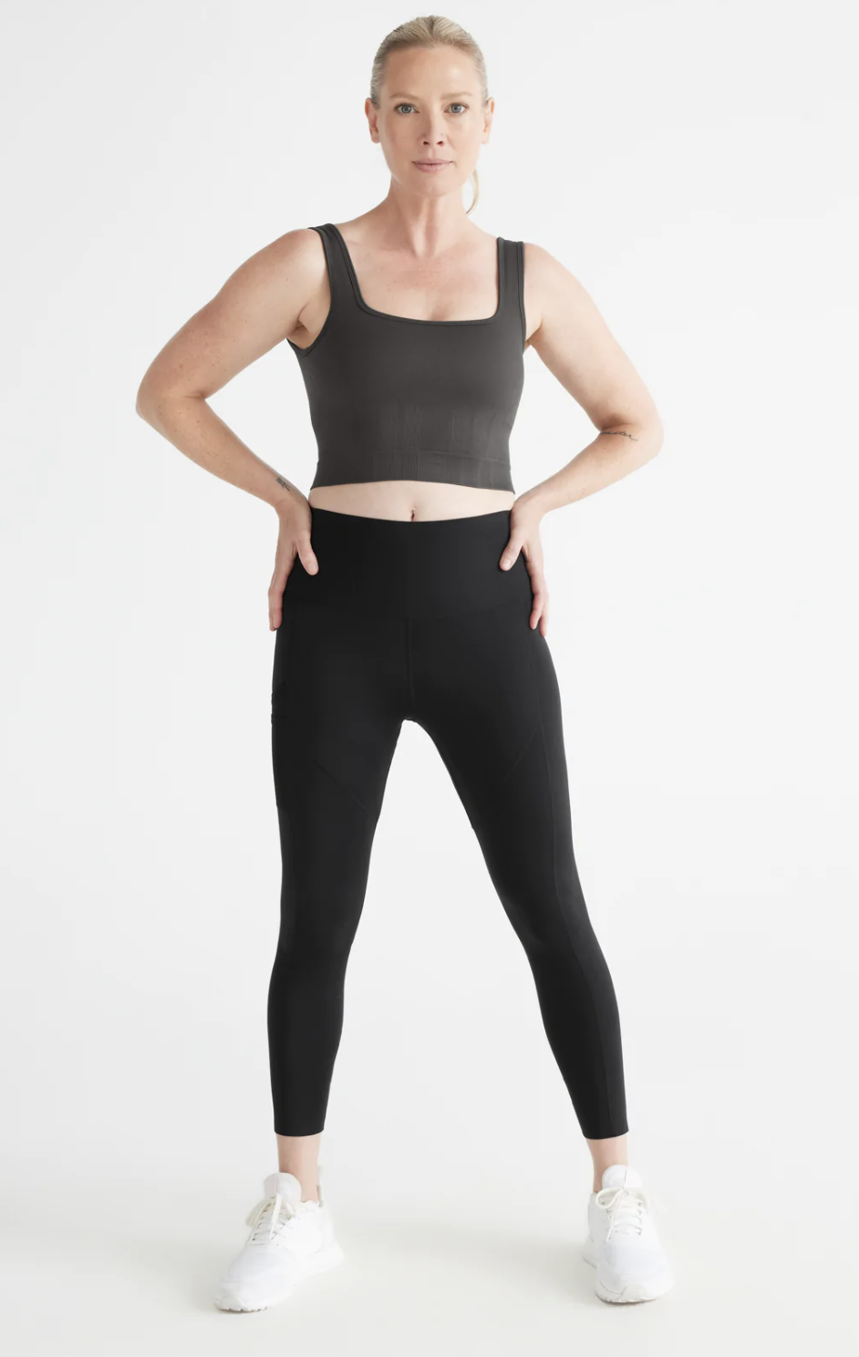 model wearing black leggings and Good to Go Seamless Crop Tank in Charcoal (photo via Knix)