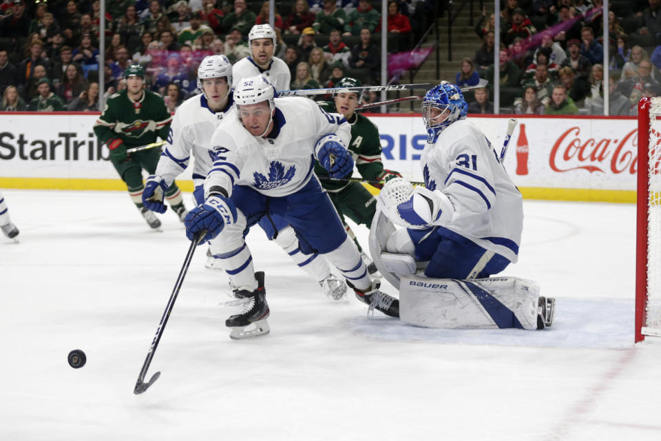 Toronto Maple Leafs defenseman Martin Marincin (52) reaches for the puck as goalie Frederik Anderson (31), with the Minnesota Wild left wing Zach Parise (11) and Toronto Maple Leafs right wing Mitchell Marner (16) watch in the first period of an NHL hockey game Tuesday, Dec. 31, 2019, in St. Paul, Minn. (AP Photo/Andy Clayton-King)