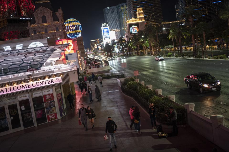People walk along the Las Vegas Strip, Monday, Nov. 9, 2020. Things have gotten better in Las Vegas since casinos were allowed to reopen in June, following the springtime shutdowns to avoid the spread of the coronavirus. But the number of visitors is still just half of what it was a year ago. (AP Photo/Wong Maye-E)