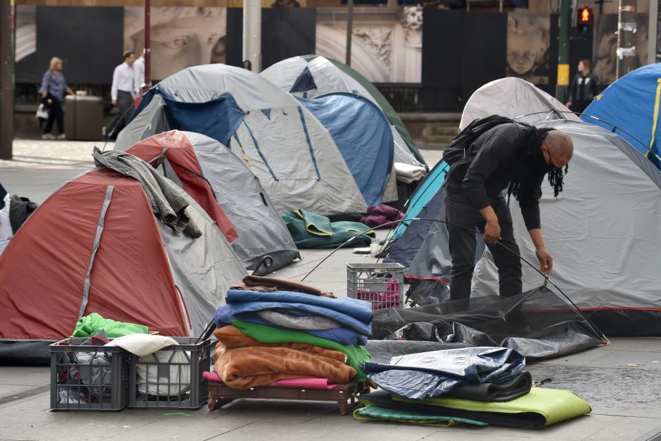 A homeless man packs up his tent in Martin Place, which has become known as "Tent City", in the central business district of Sydney on August 11, 2017. A homeless tent city in the heart of Sydney was being dismantled on August 11, after political wrangling over who was responsible for the plight of those sleeping rough in the midst of winter sparked the introduction of new laws. / AFP PHOTO / Peter PARKS        (Photo credit should read PETER PARKS/AFP via Getty Images)