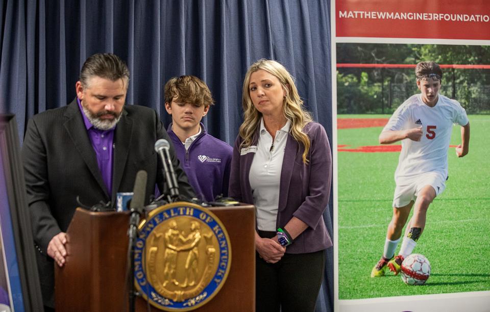 Matthew Mangine, left, paused while speaking about the need for AEDs on the sidelines while standing with his son Joseph and wife Kim during a press conference in Frankfort, KY., on Tuesday afternoon. Mangine's son, Matthew Mangine Jr., lost his life after collapsing June 16, 2020, during soccer conditioning at St. Henry District High in Erlanger.