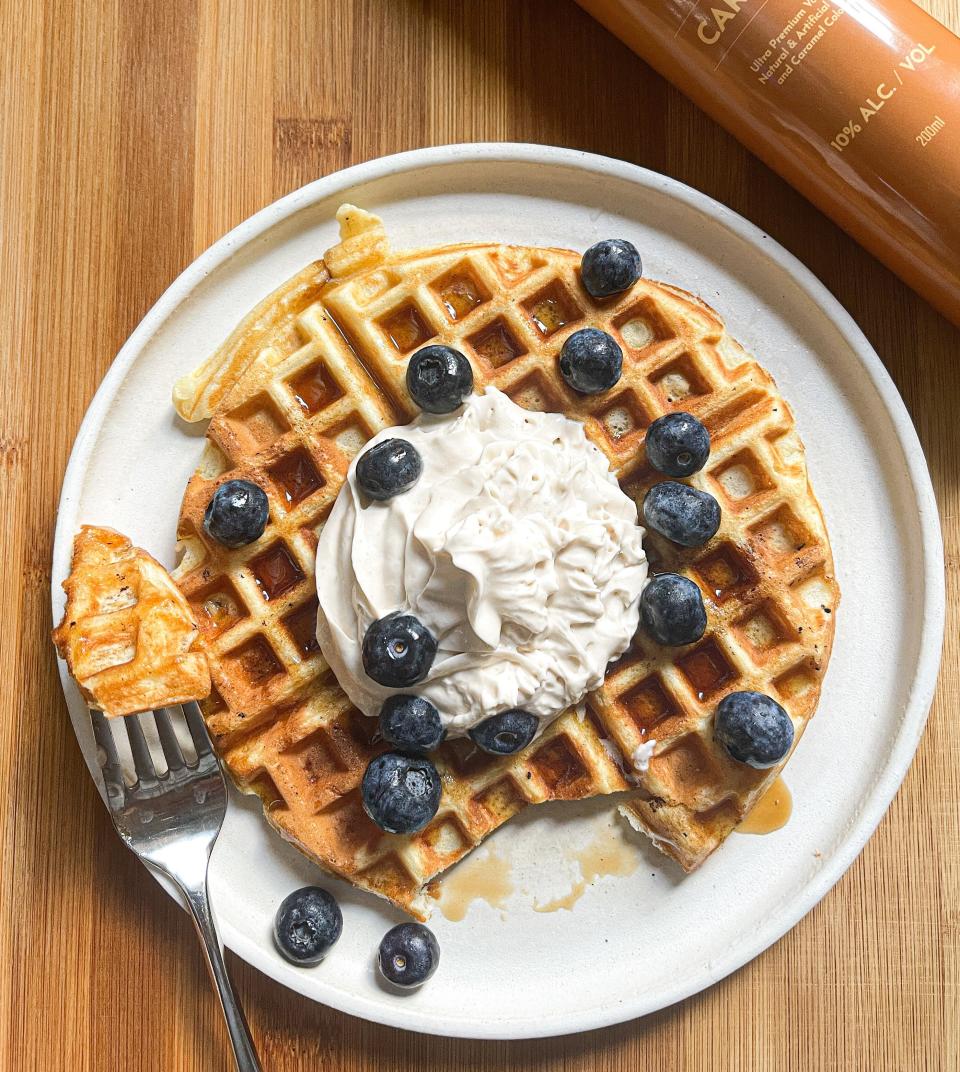 Homemade waffles with blueberries, maple syrup, and Whipshots, with the can of Caramel Whipshots in the upper-right corner