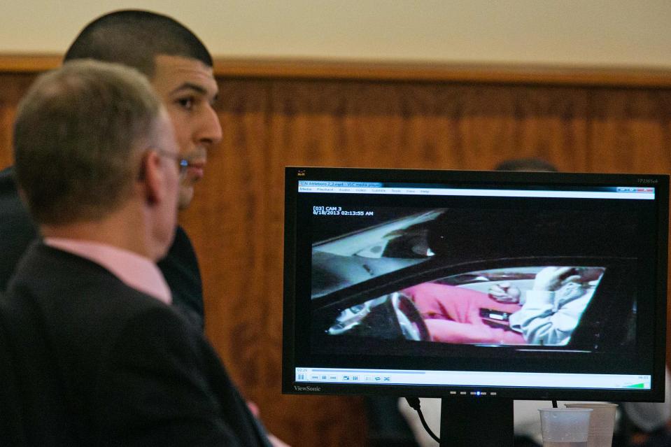 Former NFL player Aaron Hernandez (C) and his attorney Charles Rankin watch surveillance video of Hernandez handling cell phones during his murder trial at the Bristol County Superior Court in Fall River, Massachusetts, February 17, 2015. REUTERS/Dominick Reuter (UNITED STATES - Tags: CRIME LAW)