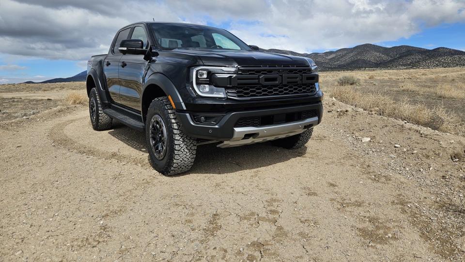 a black car parked on a dirt road