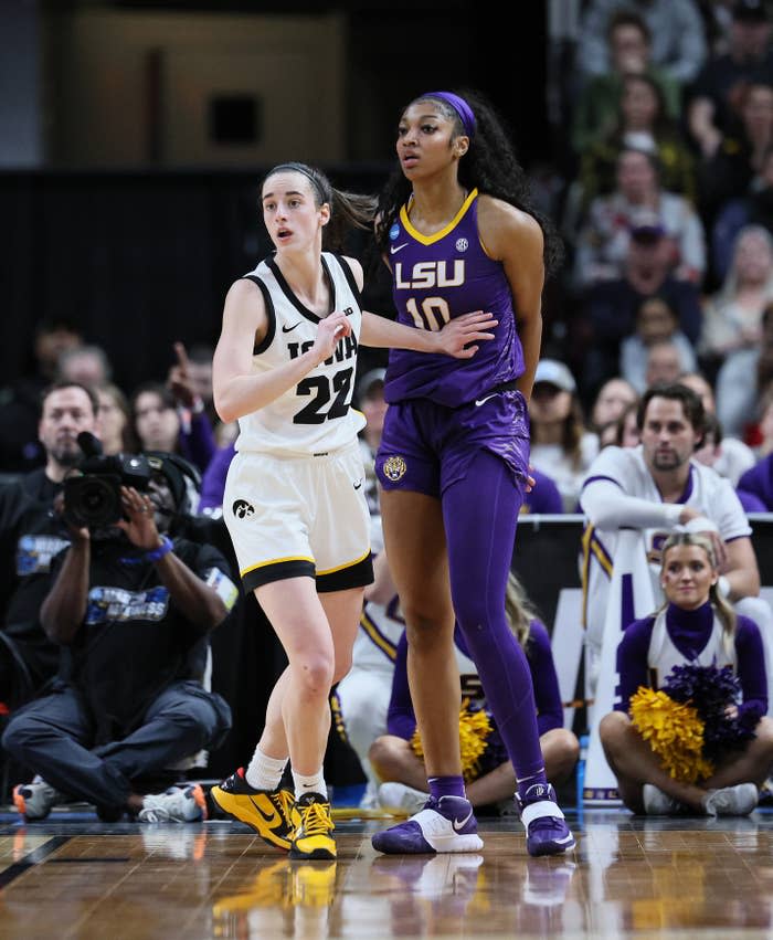 Two basketball players in action during a game, one from Iowa wearing #22 and the other from LSU wearing #10