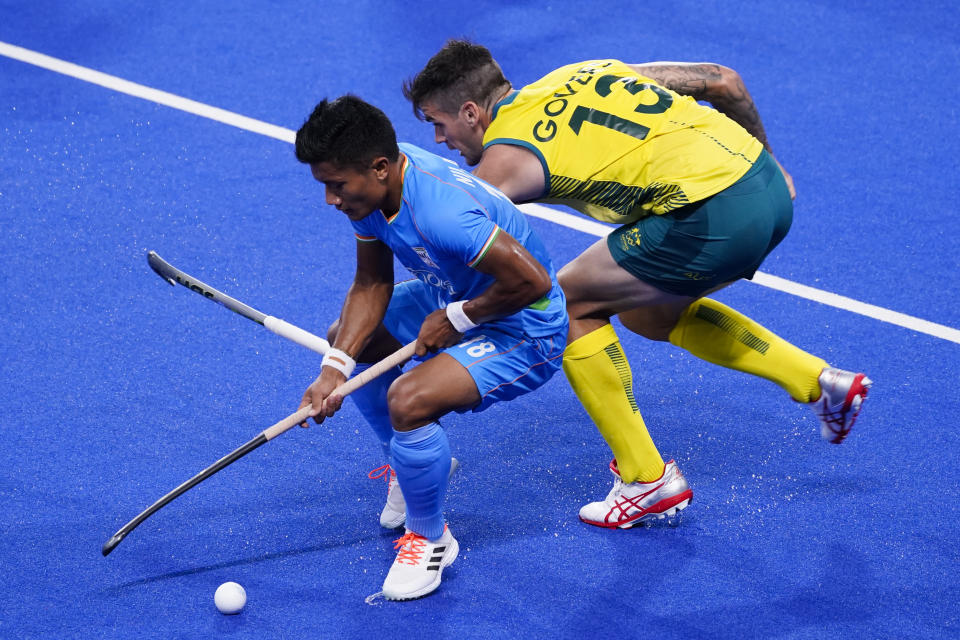 Australia's Blake Govers (13) and India's Nilakanta Sharma (18) battle for the ball during a men's field hockey match at the 2020 Summer Olympics, Sunday, July 25, 2021, in Tokyo, Japan. (AP Photo/John Minchillo)