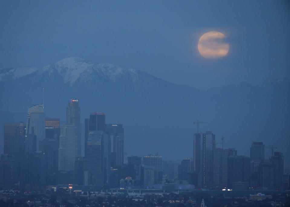 A supermoon rises behind the downtown Los Angeles skyline, as seen from Kenneth Hahn Park in Los Angeles, Sunday, Jan. 20, 2019. The year's first supermoon, when a full moon appears a little bigger and brighter thanks to its slightly closer position to Earth, is one of two lunar events Sunday. If skies are clear, a total eclipse will also be visible in North and South America, and parts of Europe. (AP Photo/Ringo H.W. Chiu)