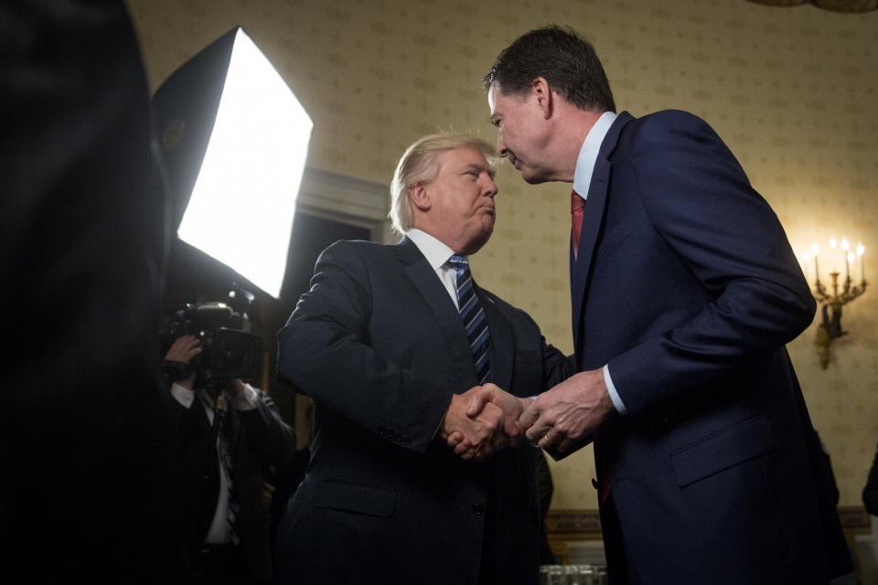 U.S. President Donald Trump, left, shakes hands with James Comey, director of the Federal Bureau of Investigation (FBI), during an Inaugural Law Enforcement Officers and First Responders Reception in the Blue Room of the White House in Washington, D.C., on Jan. 22, 2017. | Andrew Harrer—Bloomberg via Getty Images