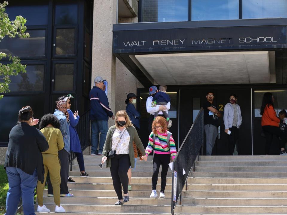 Parents wait to pick up their children at Walt Disney Magnet School in Chicago on Tuesday (AP)