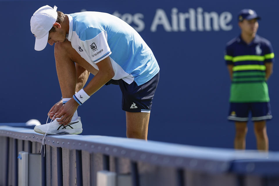 Matteo Arnaldi, of Italy, ties his shoelace during a match against Cameron Norrie, of Great Britain, during the third round of the U.S. Open tennis championships, Saturday, Sept. 2, 2023, in New York. (AP Photo/Adam Hunger)