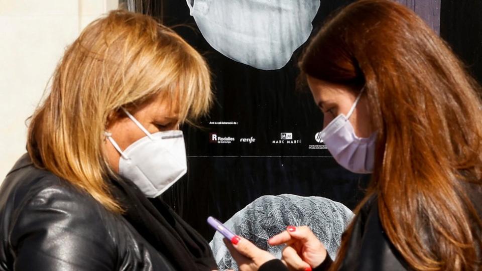 Two women wearing masks