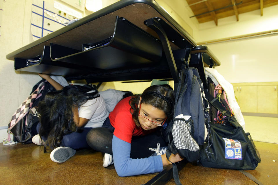 FILE - In this Oct. 15, 2009 file photo, children participate in the "Great California ShakeOut" earthquake drill at the Para Los Ninos Elementary School in Los Angeles. Millions in the United States and several countries are set to participate in an earthquake preparedness drill, dubbed the “Great ShakeOut," Thursday, Oct. 18, 2012. (AP Photo/Damian Dovarganes, File)