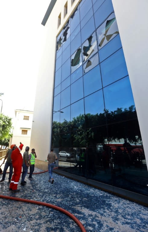 Firefighters and rescuers gather in front of the headquarters of Libya's National Oil Company in the capital Tripoli on September 10, 2018, responding to an attack claimed by the Islamic State group