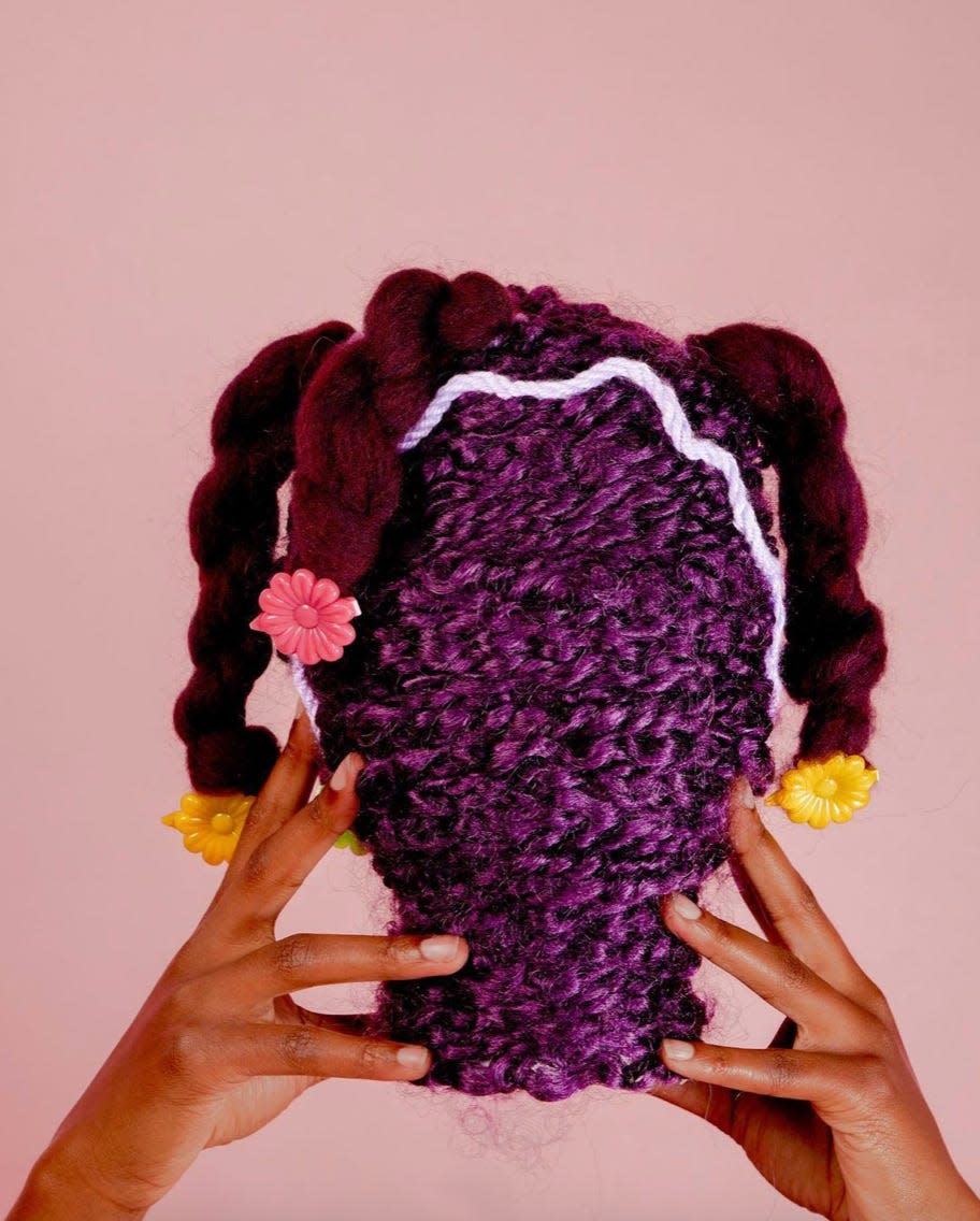 Hand Model Niani Simeone holds Mia Crews' sculpture 'Dear, Little Black Girls Who Wear Barrettes.'