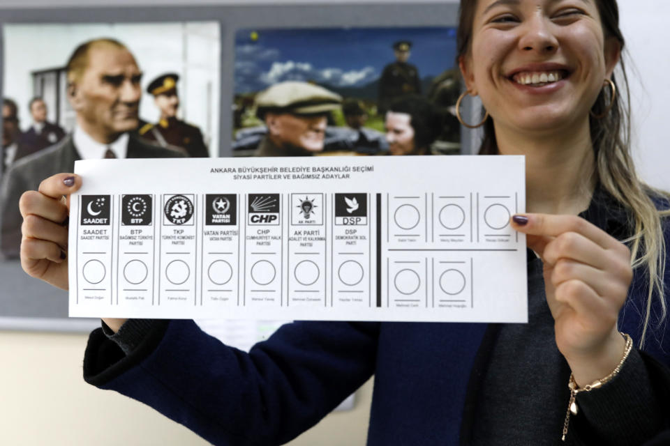 An official female shows the ballot voting paper with names and the parties a polling station during the municipal elections in Ankara, Turkey, Sunday, March 31, 2019. Turkish citizens have begun casting votes in municipal elections for mayors, local assembly representatives and neighborhood or village administrators that are seen as a barometer of Erdogan's popularity amid a sharp economic downturn. (AP Photo/Burhan Ozbilici)