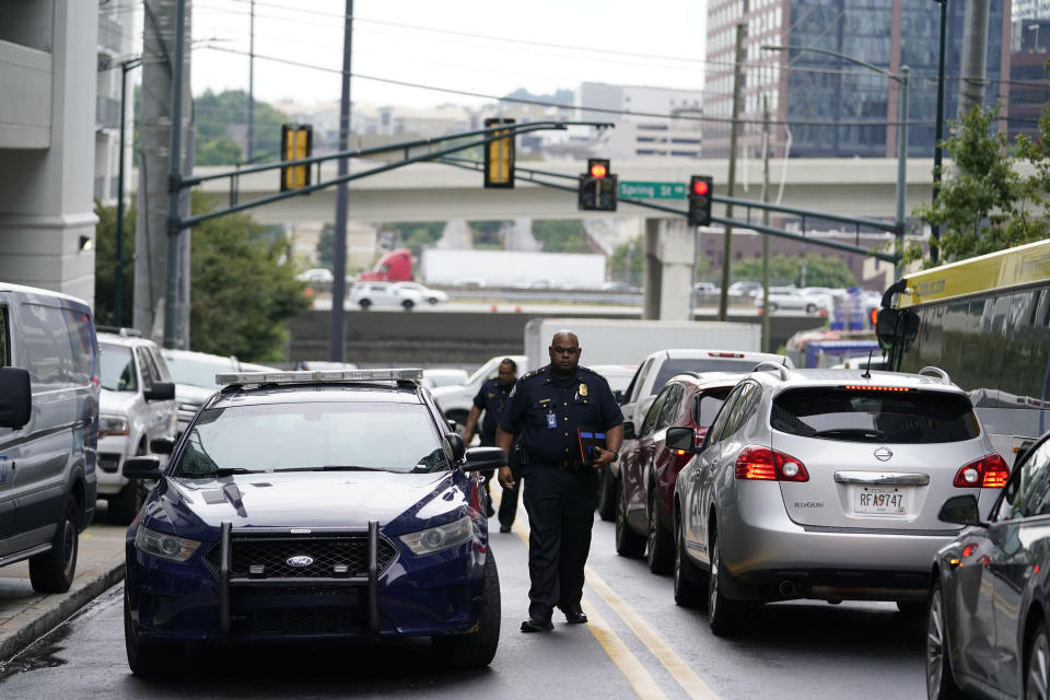 A police officer arrives on scene where a shooting occurred, Monday, Aug. 22, 2022, at a condominium in Atlanta. (AP Photo/Brynn Anderson)