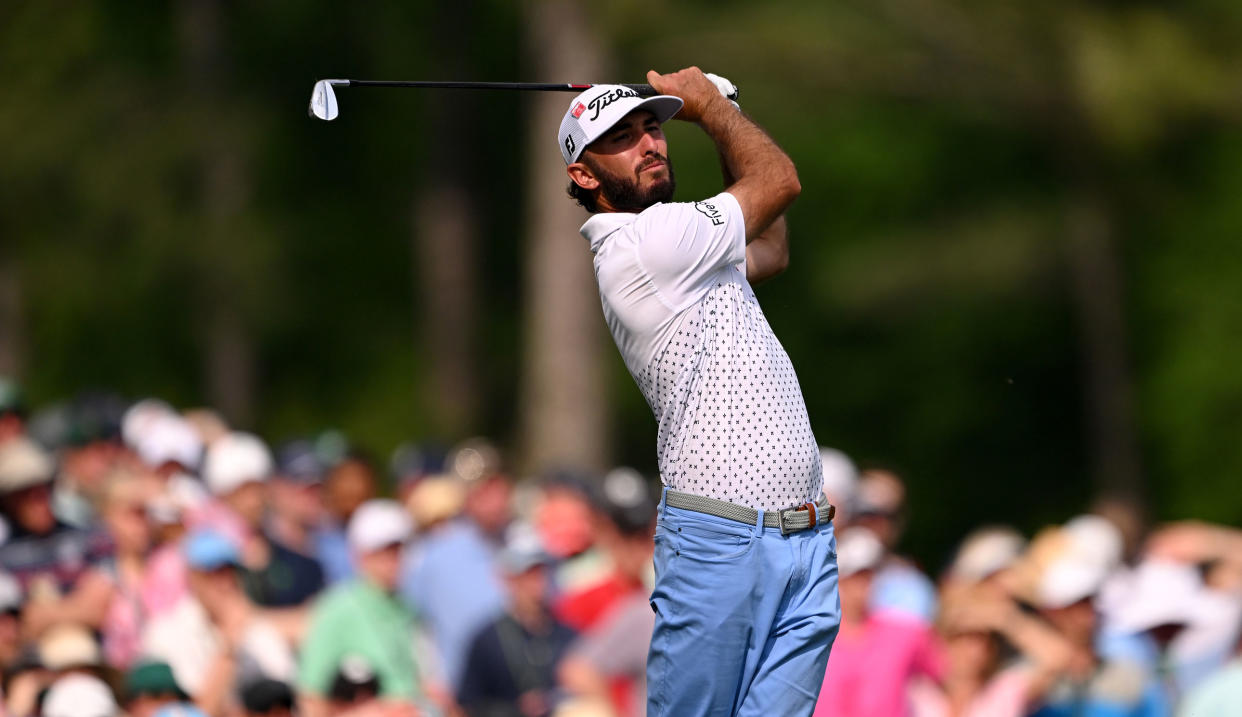  Homa strikes his iron shot and watches the flight  