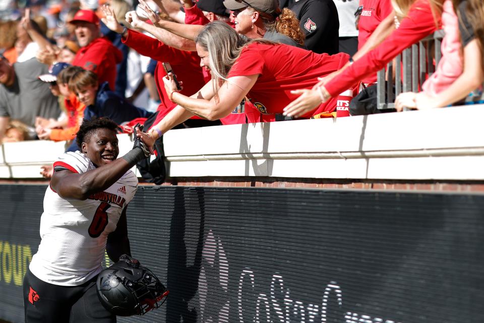 Oct 8, 2022; Charlottesville, Virginia, USA; Louisville Cardinals defensive lineman YaYa Diaby Diaby (6) celebrates with fans in the stands while leaving the field after the Cardinals' game against the Virginia Cavaliers at Scott Stadium. Mandatory Credit: Geoff Burke-USA TODAY Sports