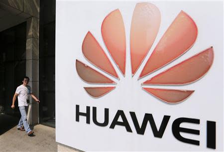 A man walks past a Huawei company logo outside the entrance of a Huawei office in Wuhan, Hubei province in this October 9, 2012 file photograph. REUTERS/Stringer/Files