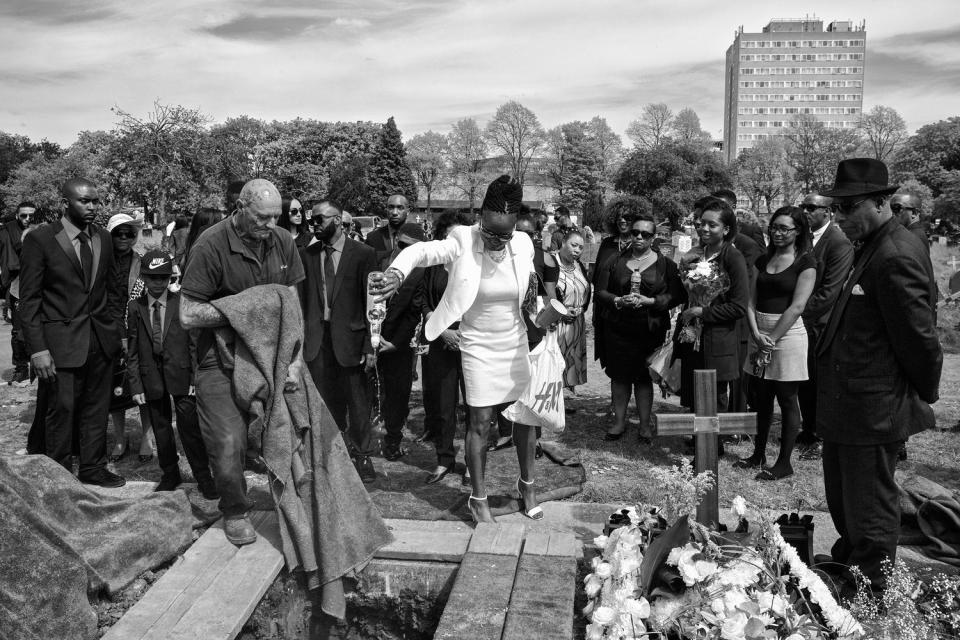 Pouring rum into a grave in Lambeth Cemetery in Tooting, South London (Jim Grover)