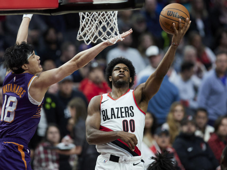 Portland Trail Blazers guard Scoot Henderson, right, shoots against Phoenix Suns forward Yuta Watanabe during the second half of an NBA preseason basketball game in Portland, Ore., Thursday, Oct. 12, 2023. (AP Photo/Craig Mitchelldyer)