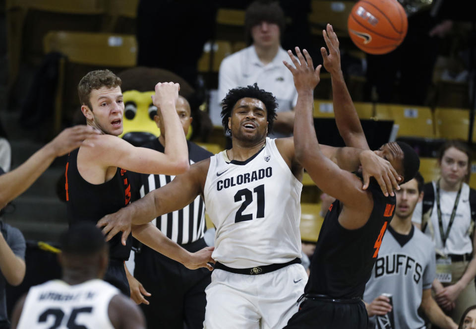 Colorado forward Evan Battey, center, passes the ball after getting trapped by Oregon State forwards Kylor Kelley, left, and Alfred Hollins in the first half of an NCAA college basketball game Sunday, Jan. 5, 2020, in Boulder, Colo. (AP Photo/David Zalubowski)