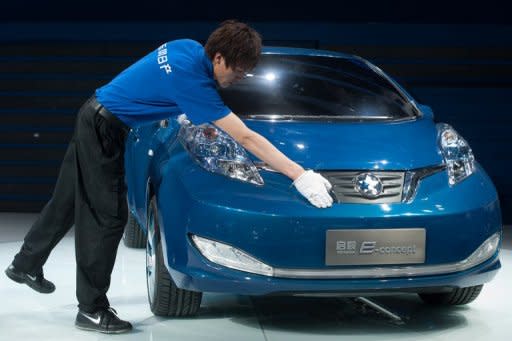 A man cleans a concept electric car by joint Nissan-Dongfeng company 'Venucia', at the Auto China 2012 car show in Beijing. Foreign carmakers in China say Beijing is pressuring them to produce dedicated new brands so their local partners can gain technical know-how, but experts warn the strategy could backfire