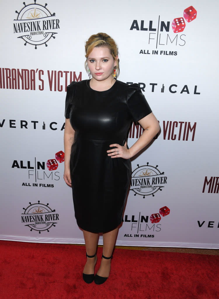 Woman in a black knee-length dress at a film premiere event